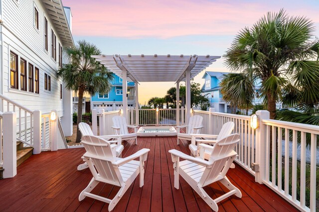 deck at dusk featuring a pergola