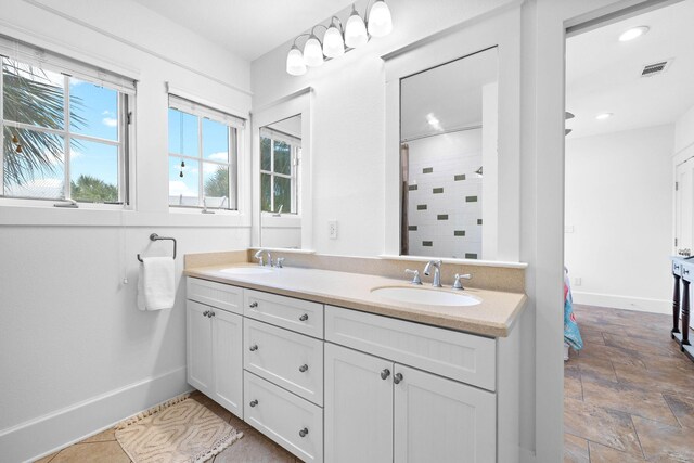 bathroom with vanity and tiled shower