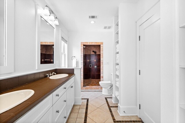 bathroom with tile patterned floors, vanity, toilet, and a shower with shower door