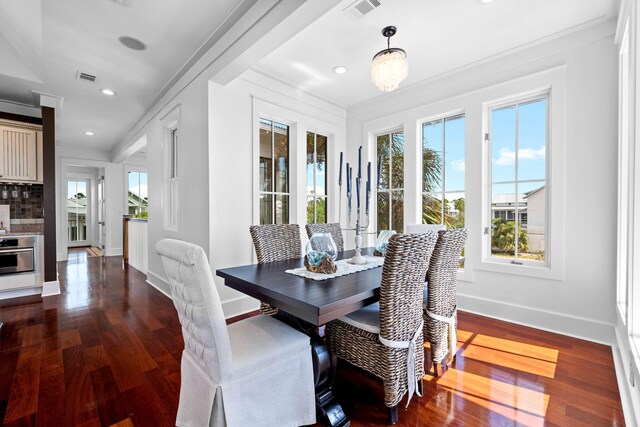 dining room with dark hardwood / wood-style floors, crown molding, and a notable chandelier