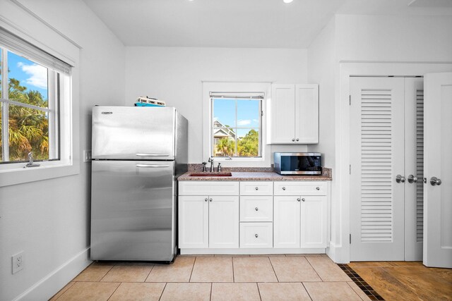 kitchen featuring white cabinets, appliances with stainless steel finishes, sink, and a wealth of natural light