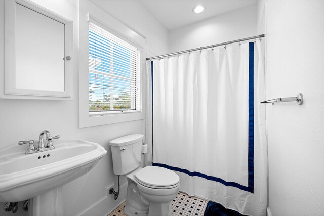 bathroom with sink, tile patterned flooring, walk in shower, and toilet