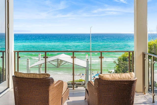 balcony featuring a water view and a view of the beach