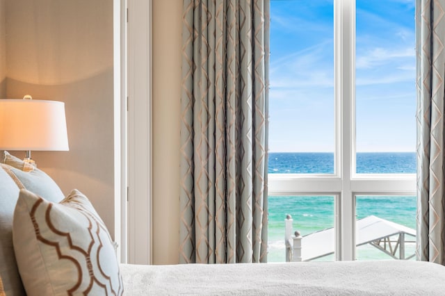 bedroom with a water view and a view of the beach