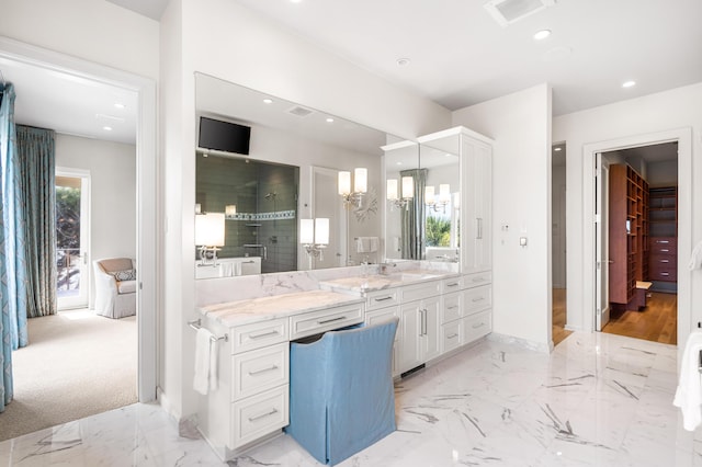 bathroom with a notable chandelier, vanity, and a shower