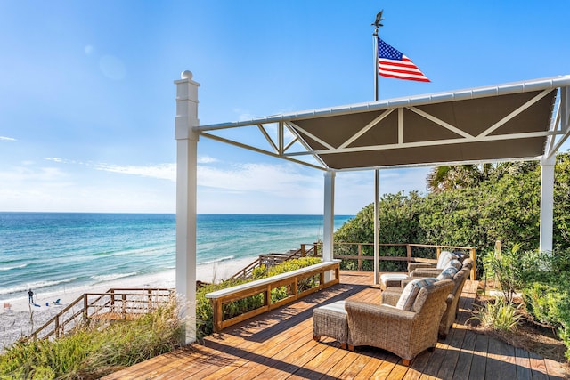 deck featuring a view of the beach, an outdoor living space, and a water view