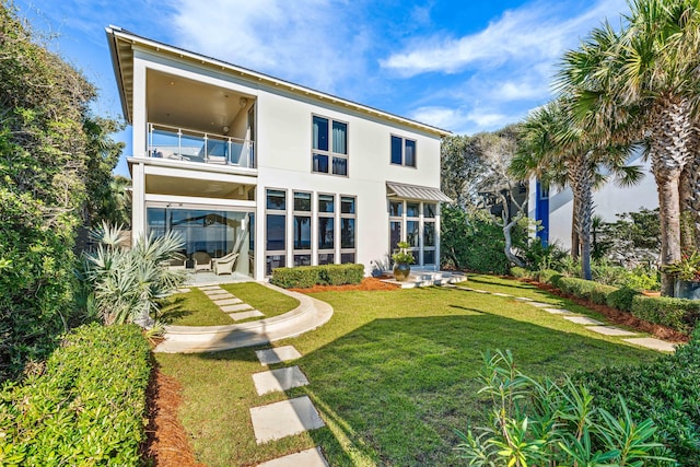 back of house featuring a balcony and a lawn