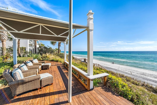 wooden terrace featuring a beach view and a water view