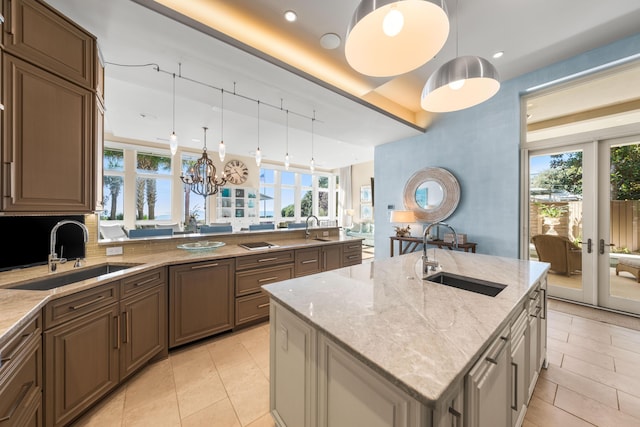 kitchen with pendant lighting, an island with sink, and sink