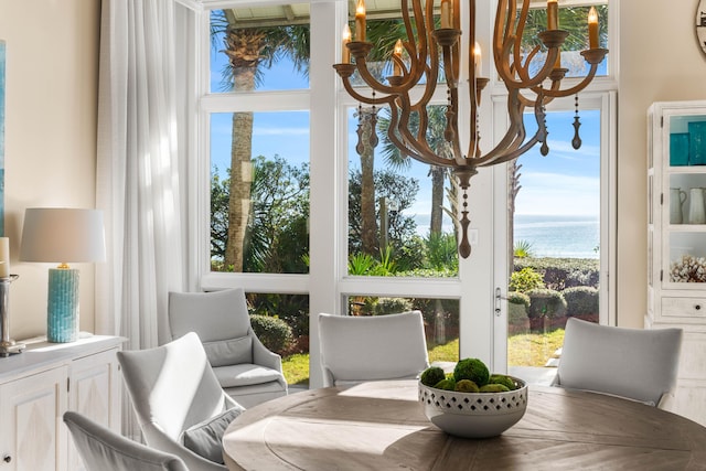 sunroom / solarium with a notable chandelier and a water view