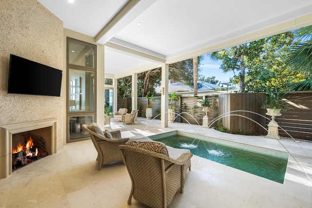 view of pool featuring pool water feature, a large fireplace, and a patio