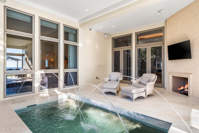 view of swimming pool with pool water feature, french doors, and a jacuzzi