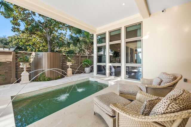 view of swimming pool with pool water feature and a patio