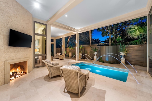 view of pool featuring pool water feature, an outdoor fireplace, and a patio