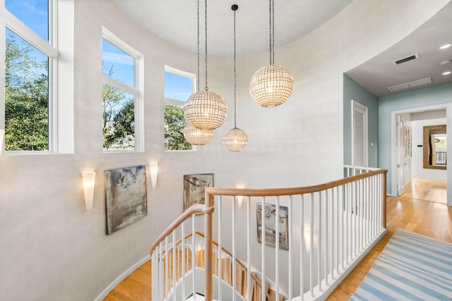 hall with a notable chandelier and light wood-type flooring