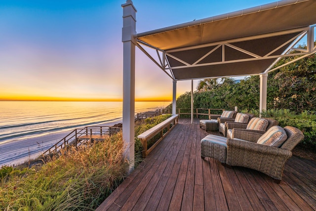 deck at dusk featuring a water view