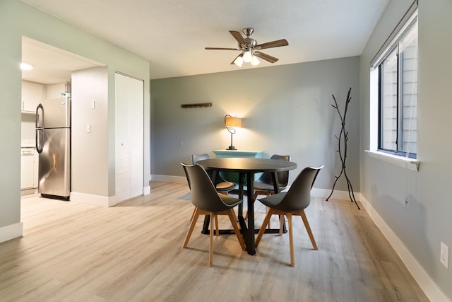 dining room with light hardwood / wood-style flooring, a textured ceiling, and ceiling fan