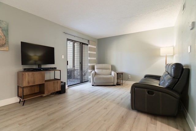 living room with light hardwood / wood-style flooring and a textured ceiling