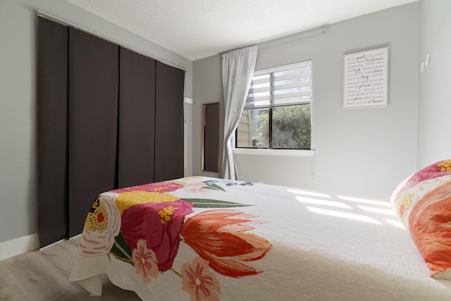 bedroom with hardwood / wood-style flooring and a textured ceiling