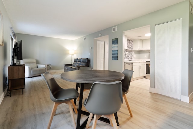 dining room with light wood-type flooring and sink