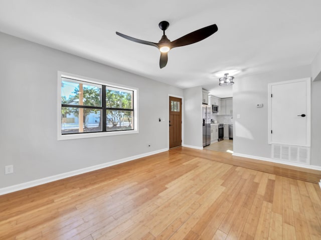 unfurnished living room featuring ceiling fan and light hardwood / wood-style flooring