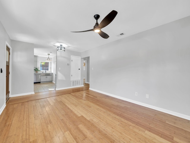 unfurnished living room with ceiling fan, light wood-type flooring, and sink