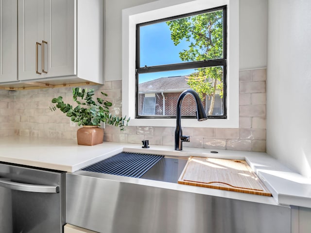 details with white cabinets, tasteful backsplash, and stainless steel dishwasher