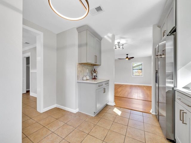 kitchen featuring high end fridge, light tile patterned floors, and gray cabinetry