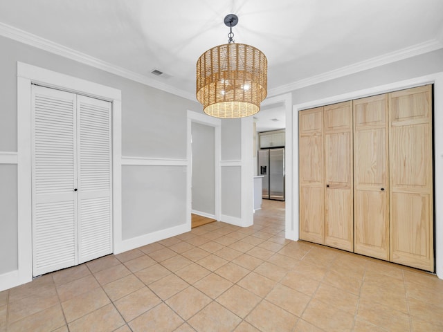 unfurnished dining area featuring ornamental molding, a chandelier, and light tile patterned floors