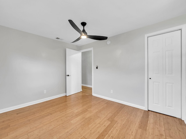 unfurnished bedroom featuring a closet, light hardwood / wood-style flooring, and ceiling fan