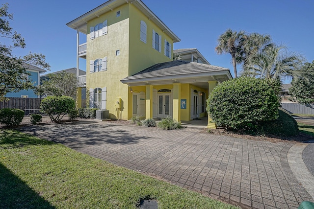 exterior space with fence, french doors, central air condition unit, and stucco siding