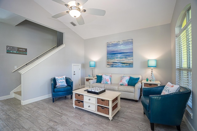 living area with lofted ceiling, a ceiling fan, stairs, and light wood-style flooring