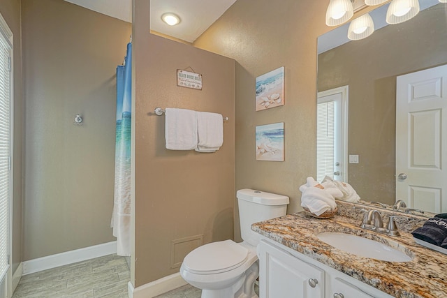 bathroom featuring baseboards, toilet, vanity, and a shower with shower curtain
