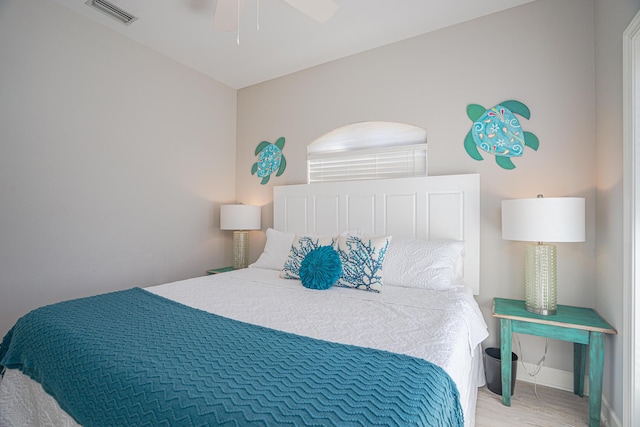 bedroom featuring ceiling fan, baseboards, visible vents, and light wood-type flooring