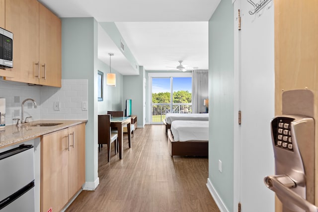 interior space featuring access to exterior, light wood-type flooring, and sink