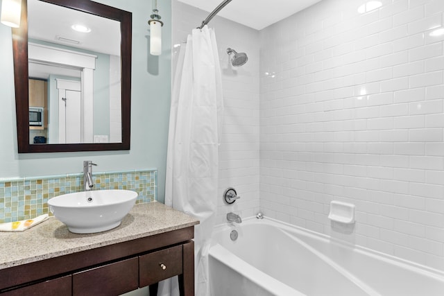 bathroom featuring shower / bath combination with curtain, backsplash, and vanity