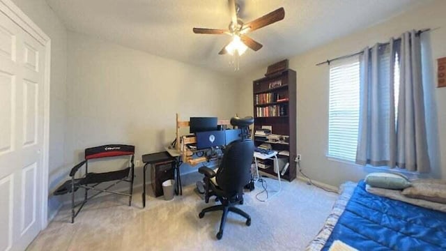 carpeted home office with lofted ceiling and ceiling fan