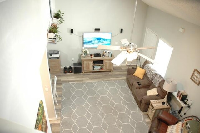 living room with ceiling fan, lofted ceiling, and light wood-type flooring