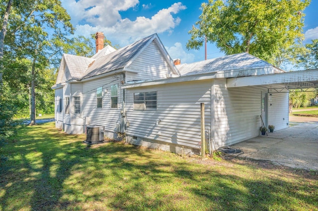 view of side of home featuring central air condition unit and a lawn