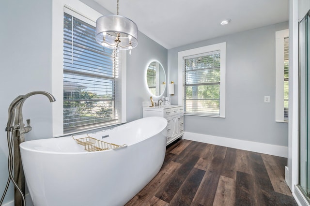 bathroom with a notable chandelier, vanity, wood-type flooring, and shower with separate bathtub