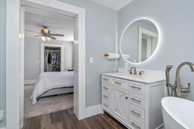 bathroom featuring hardwood / wood-style flooring, a bathing tub, ceiling fan, and vanity