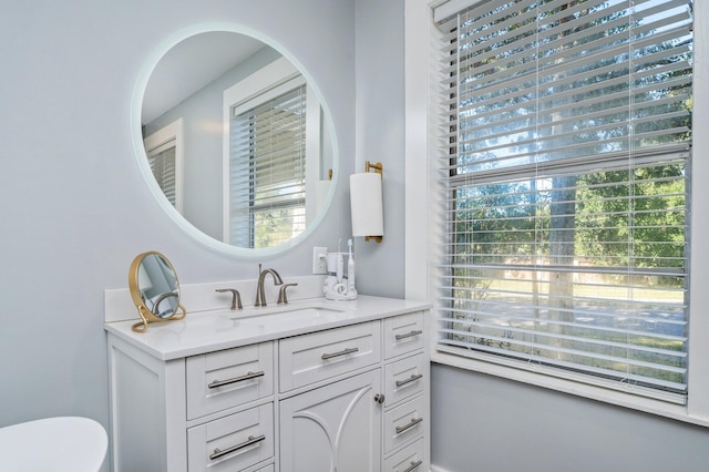 bathroom featuring vanity, plenty of natural light, and toilet