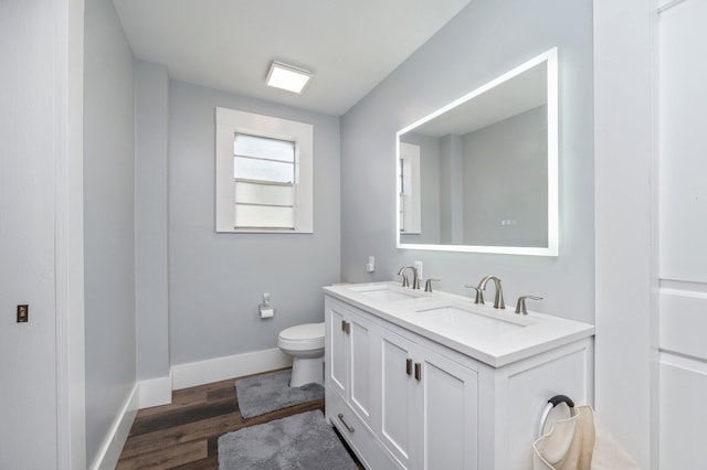 bathroom with hardwood / wood-style flooring, vanity, and toilet