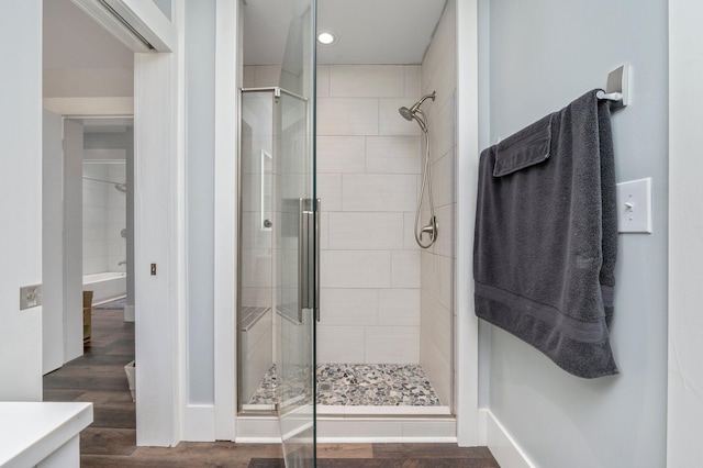 bathroom with a shower with door, hardwood / wood-style flooring, and vanity