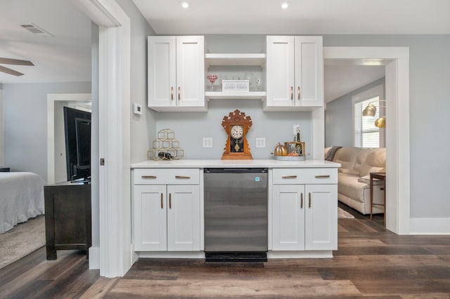 bar featuring white cabinets, dark hardwood / wood-style flooring, and stainless steel dishwasher