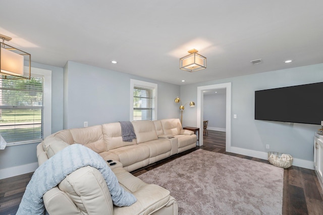 living room with a healthy amount of sunlight and dark wood-type flooring