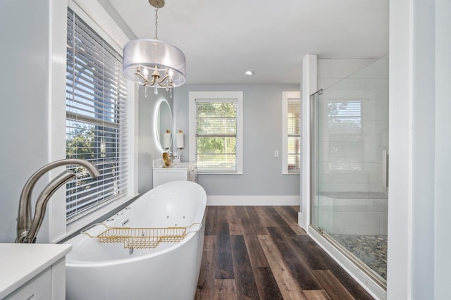 bathroom with hardwood / wood-style flooring, separate shower and tub, vanity, and an inviting chandelier