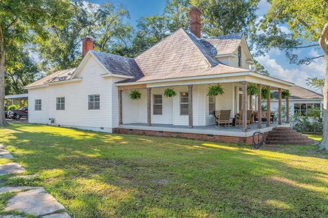 farmhouse featuring a front yard and covered porch