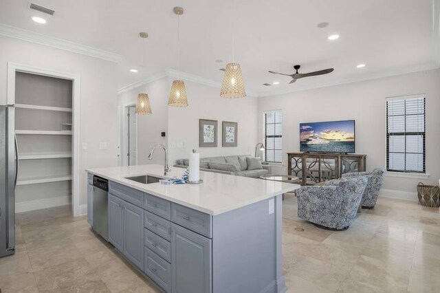 kitchen featuring pendant lighting, crown molding, a center island with sink, sink, and appliances with stainless steel finishes