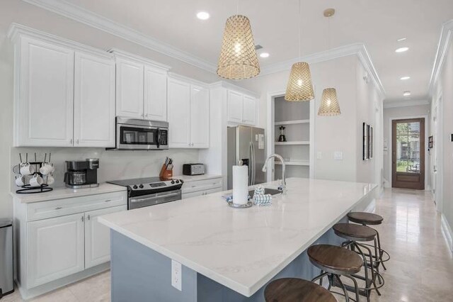 kitchen with pendant lighting, an island with sink, white cabinetry, stainless steel appliances, and light stone countertops